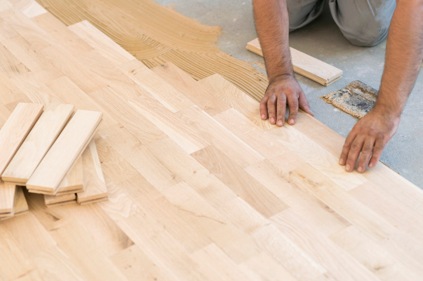 A man is DIY installing hardwood floors.